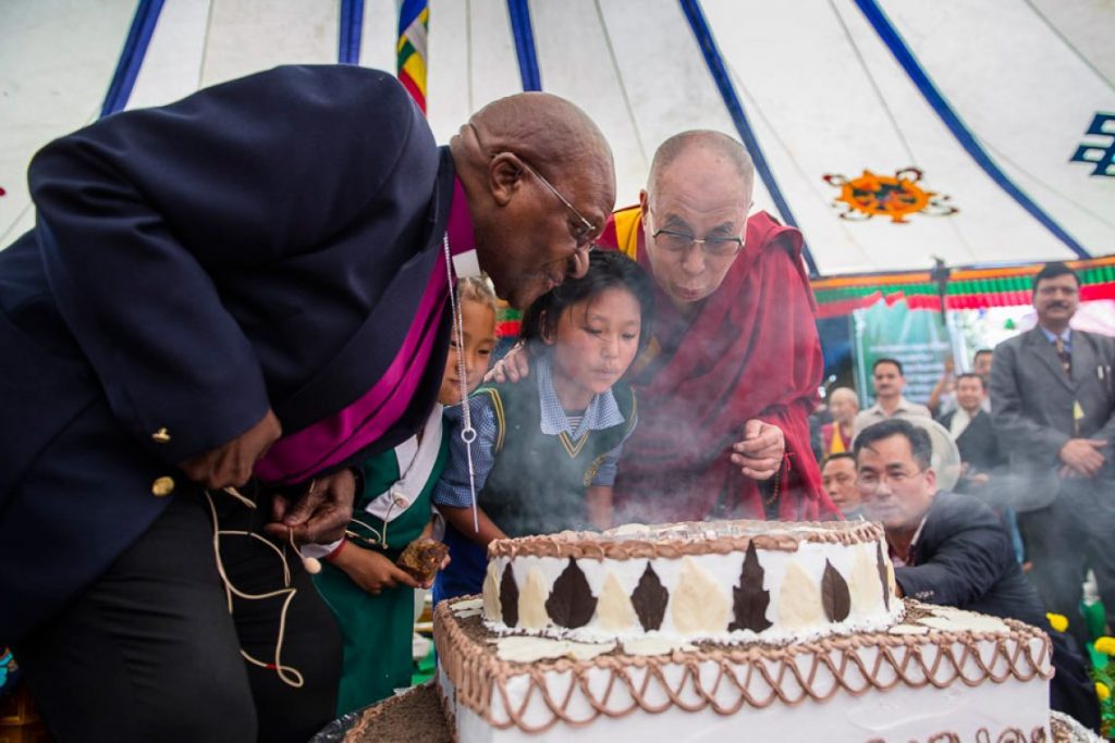 Dalai Lama and Desmond Tutu Blowing Out Candles on Birthday Cake