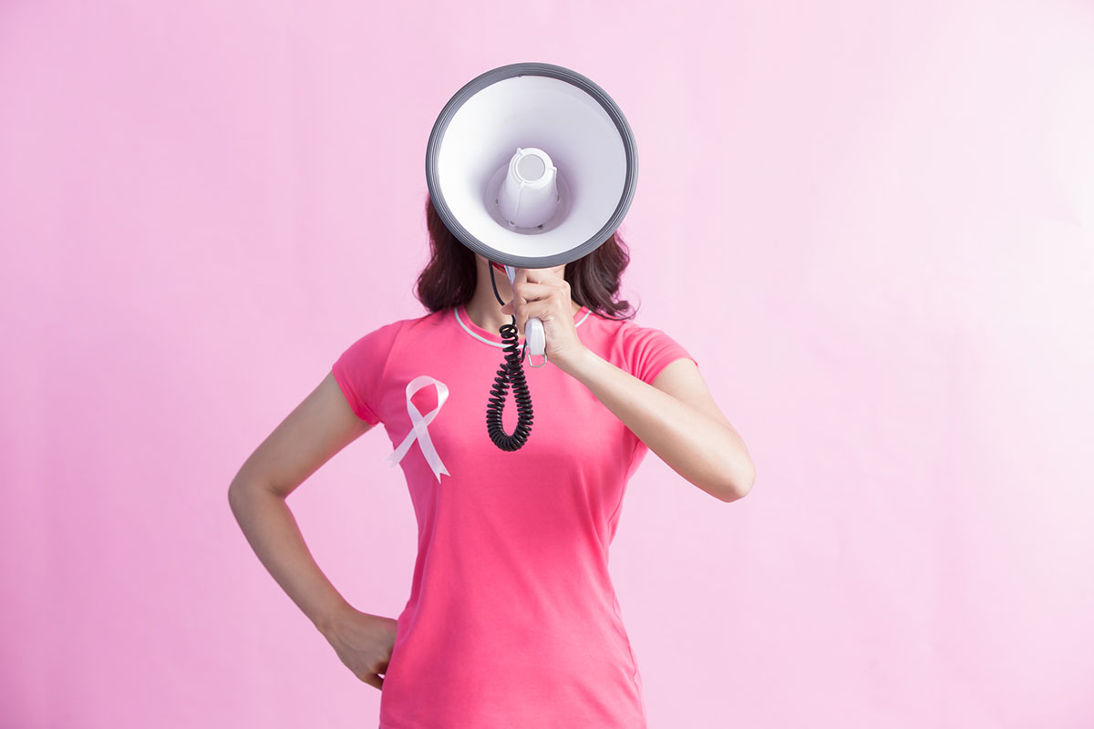 Woman Wearing a Pink T-Shirt and Ribbon Shouting into a Megaphone