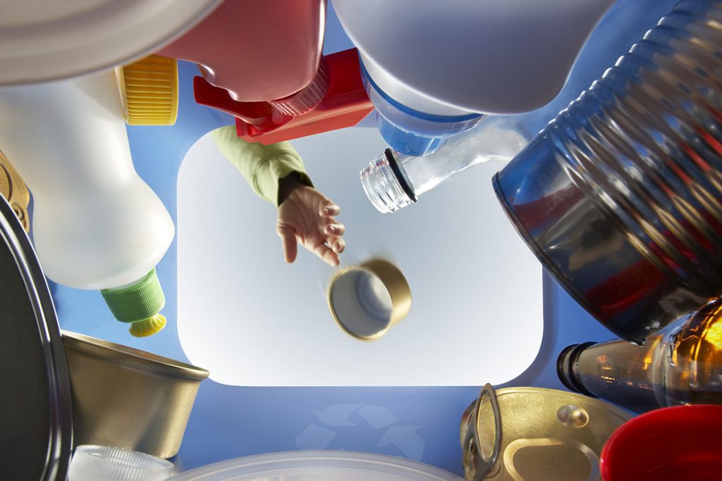View from Inside Recycling Bin Showing a Hand Tossing in a Can