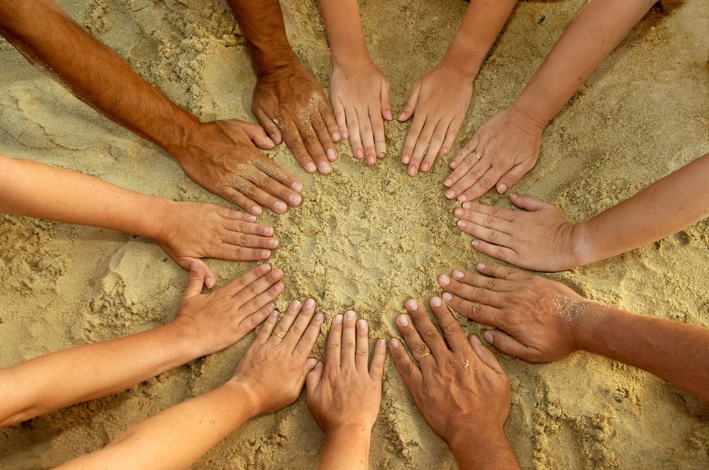 Circle of Hands Resting on Sand
